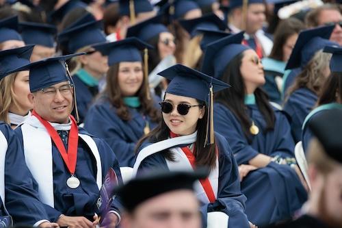 A group of seated graduates in regalia at GW Commencement