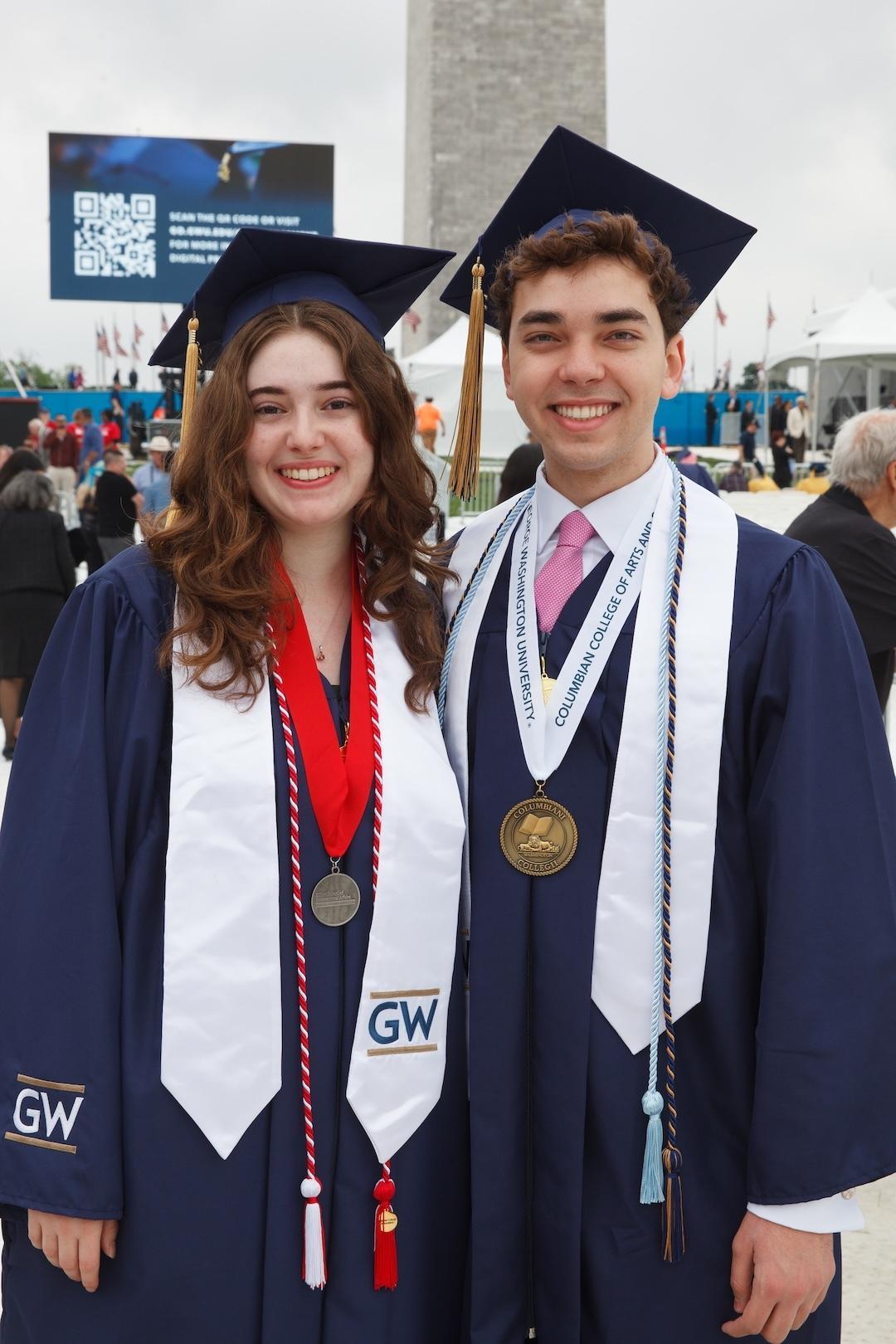 2 students pose for a photo in regalia