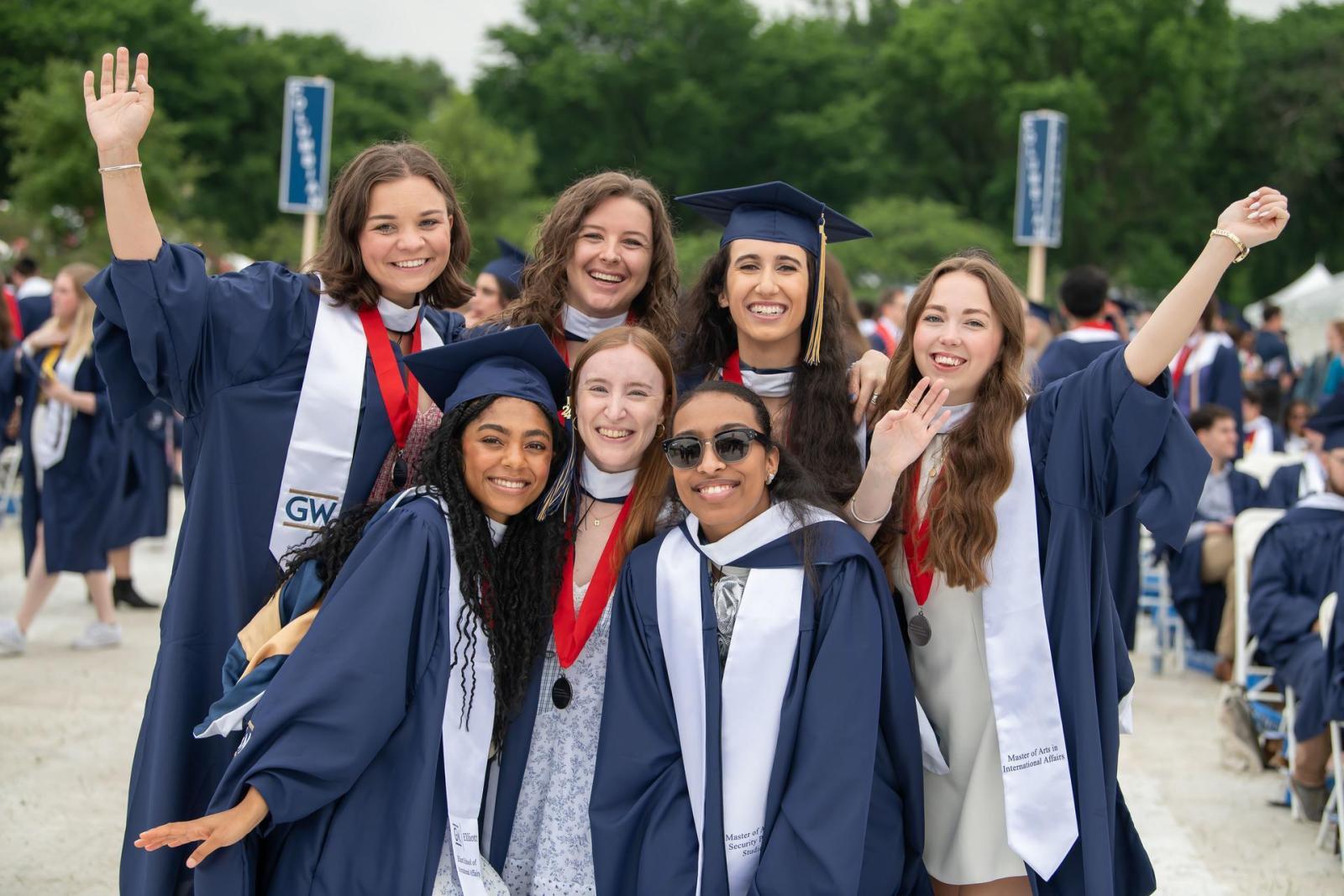 A group of students pose for a photo in regalia